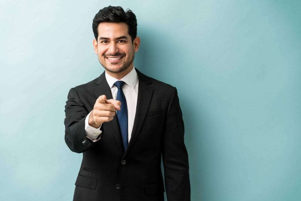 Freezone Company Formation – Other Emirates 7 confident good looking young businessman pointing finger while standing against isolated background 1