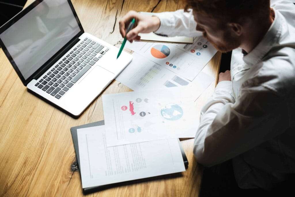 MIS Reporting and Annual Financial Analysis 1 top view young successful businessman white shirt working wooden table 1