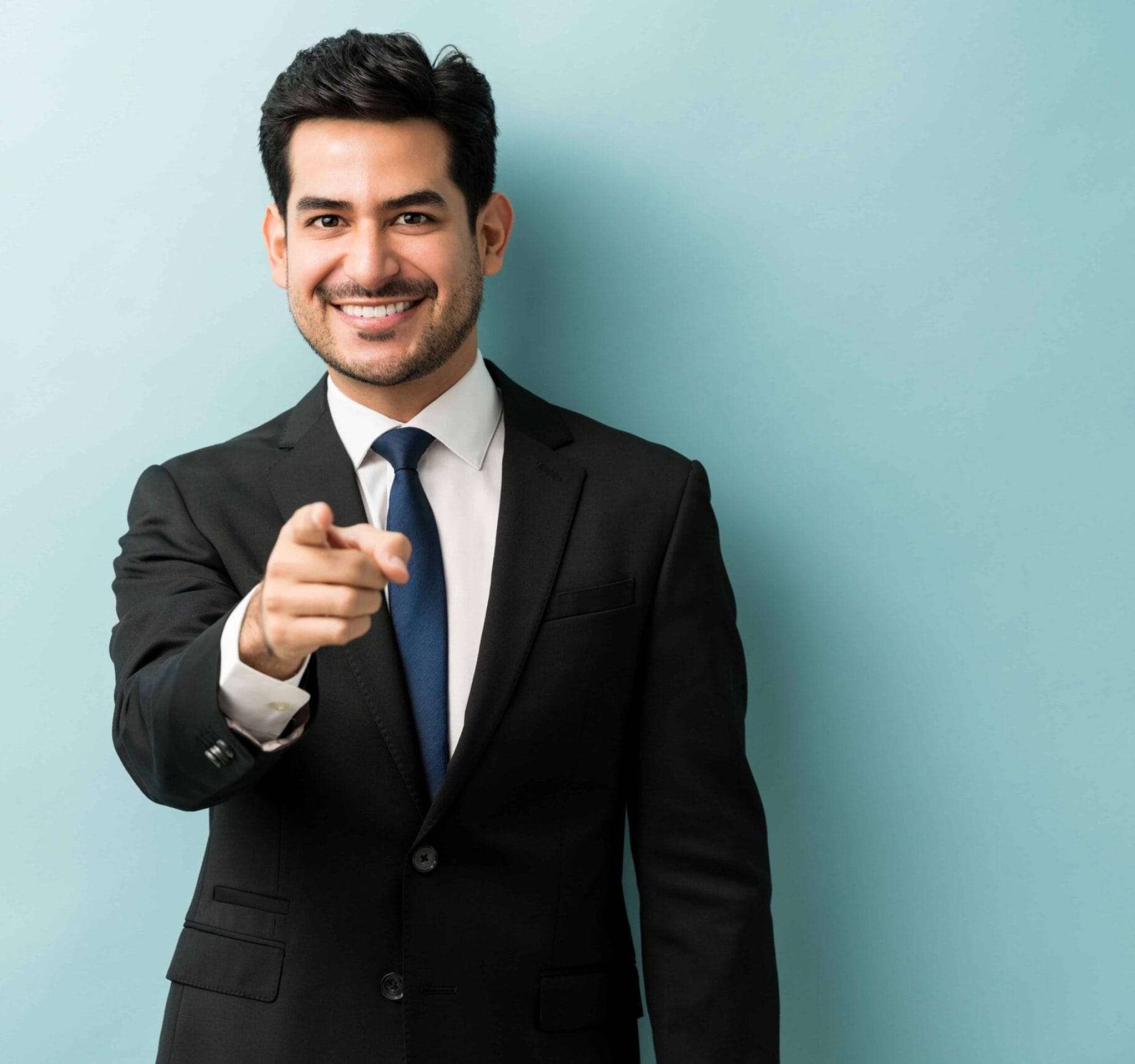 confident-good-looking-young-businessman-pointing-finger-while-standing-against-isolated-background (1)